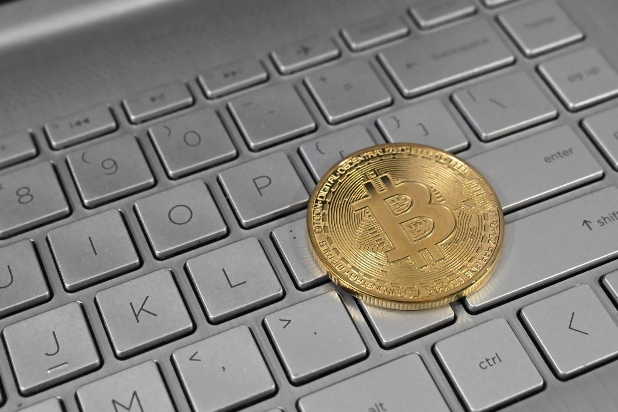 Màn hình laptop hiển thị biểu đồ giá Bitcoin đang lên và ví điện tử