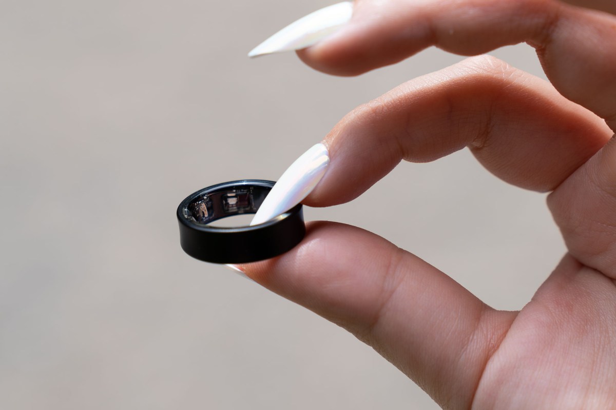 Nhẫn Galaxy Ring màu đen cầm trên tay, lộ rõ cảm biến đo sức khỏe bên trong