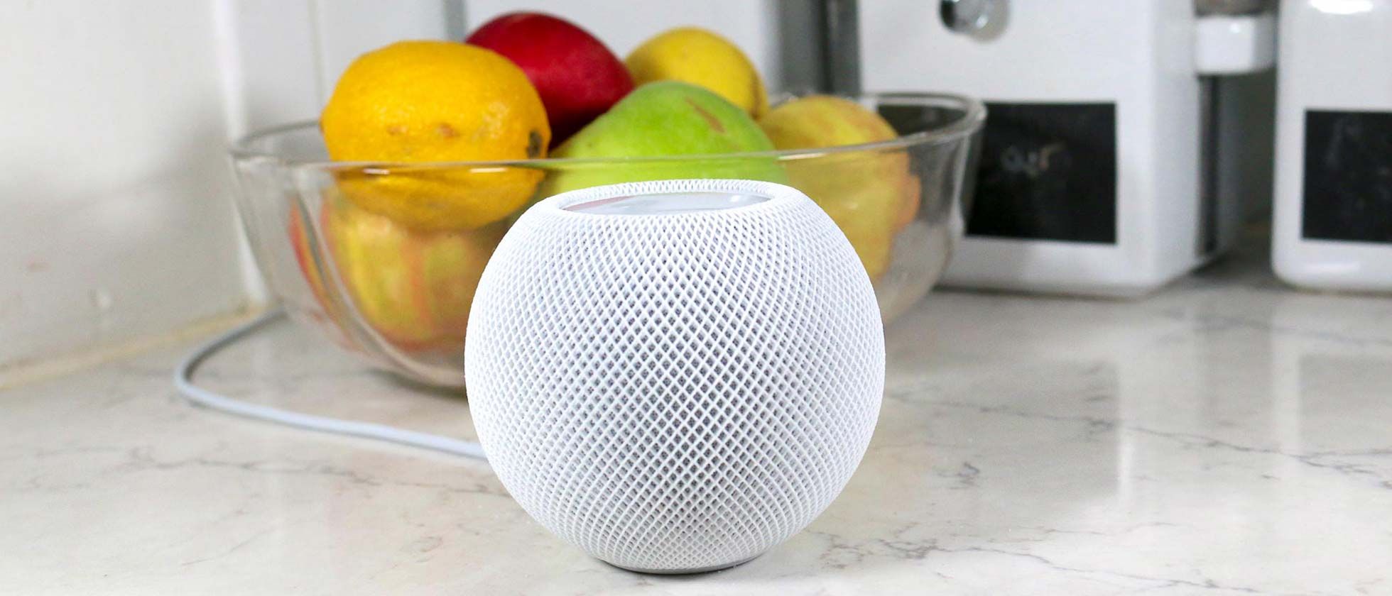 Loa thông minh Apple HomePod mini màu trắng đặt trên bàn bếp
