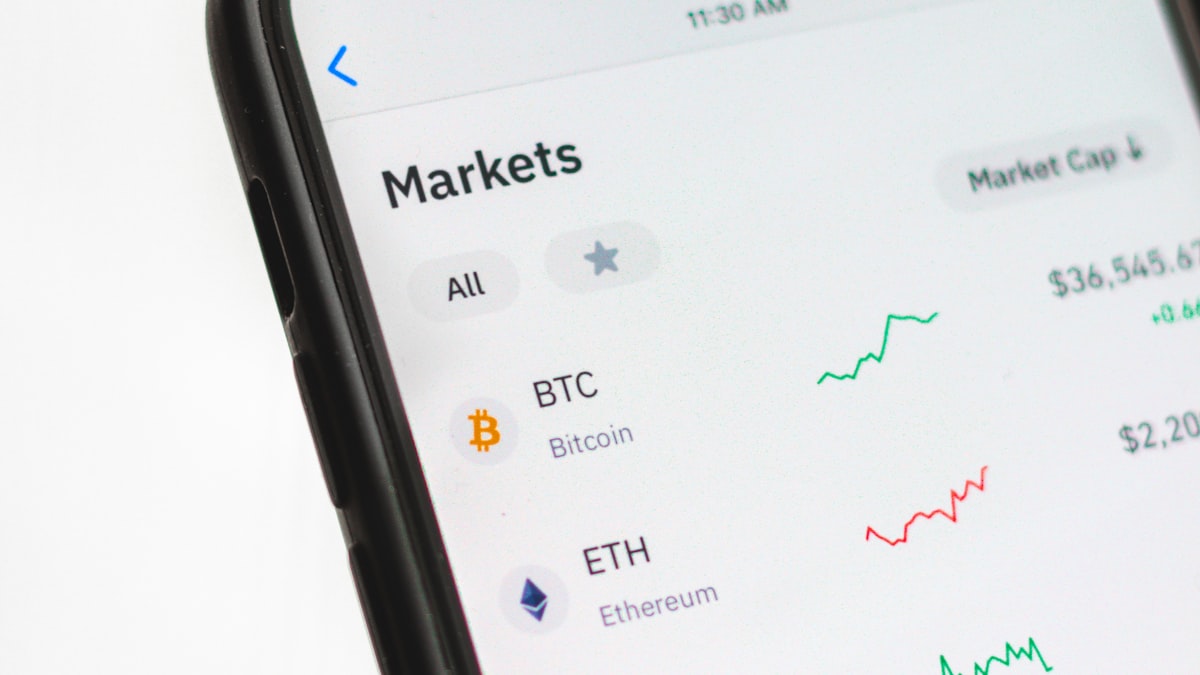Màn hình điện thoại hiển thị danh sách giá Bitcoin và Ethereum trong ứng dụng theo dõi thị trường