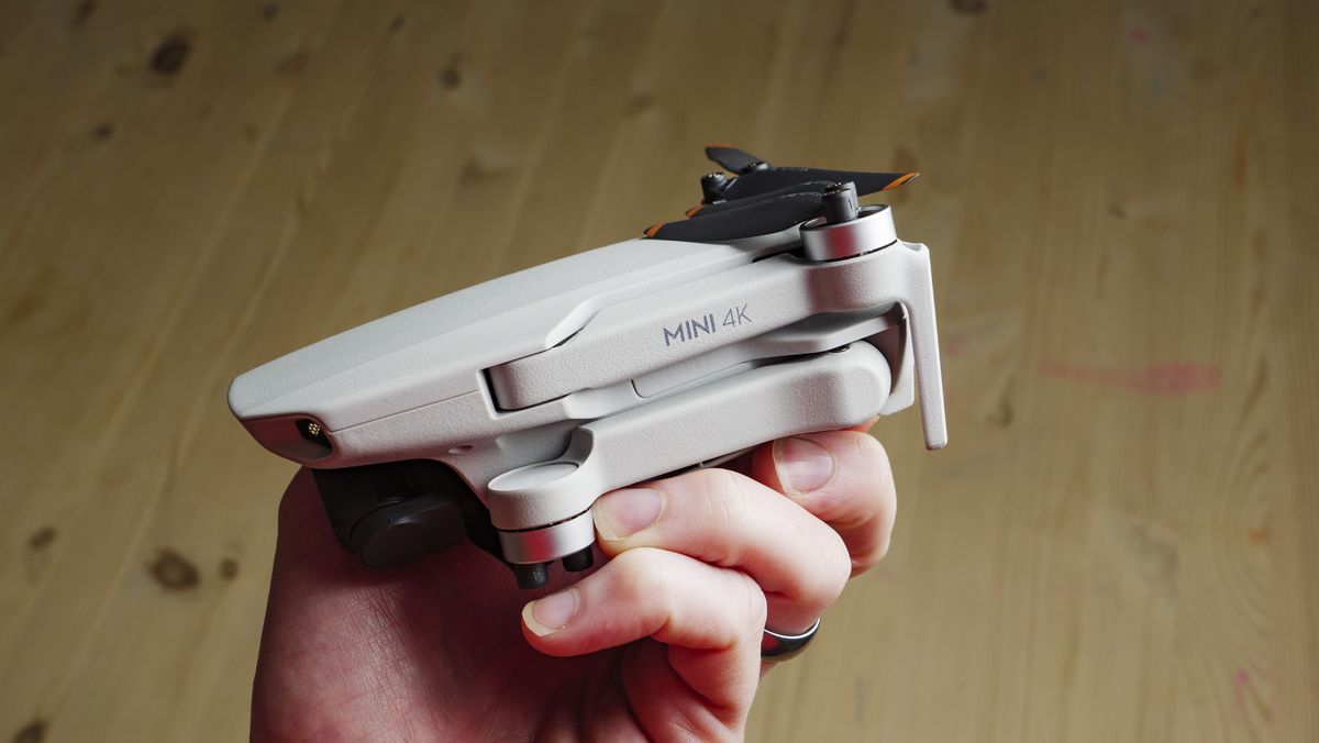 Drone mini cỡ nhỏ gọn được cầm trong bàn tay thể hiện kích thước tiện lợi