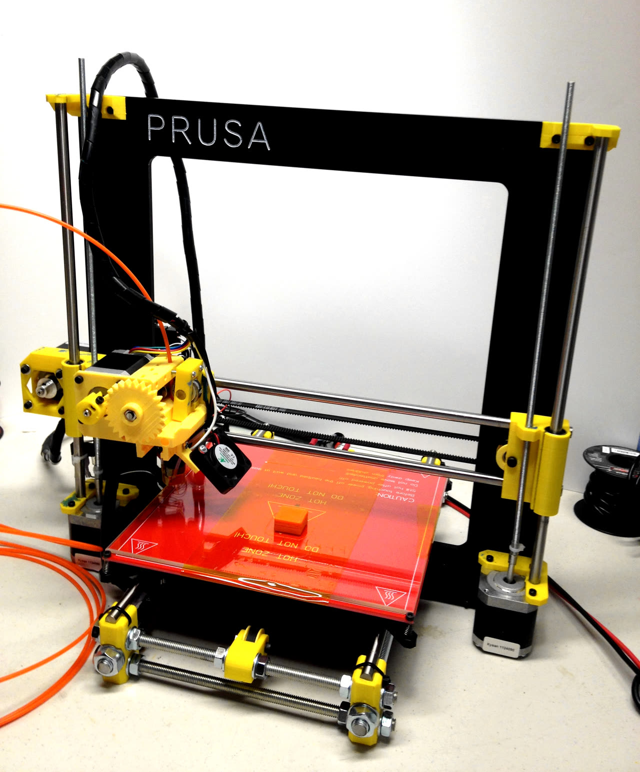 Máy in 3D Prusa i3 đang in vật thể nhựa màu xanh
