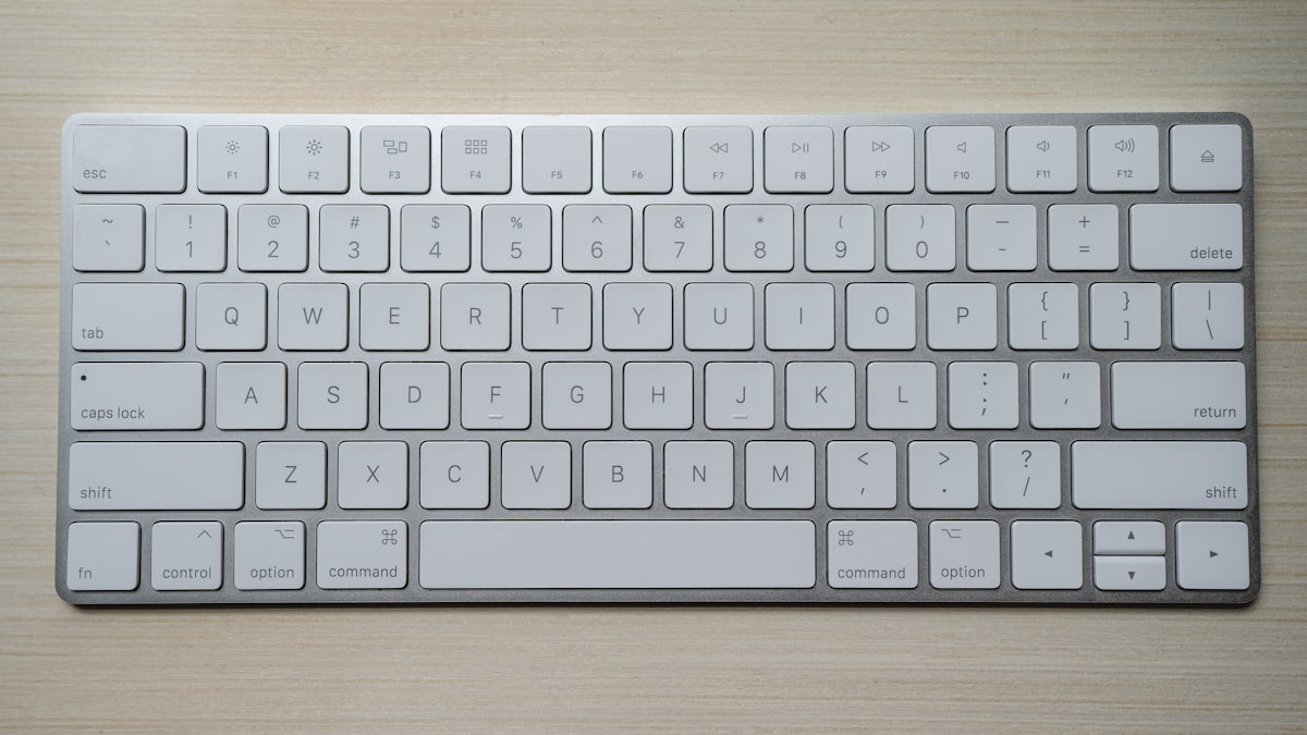 Bàn phím Apple Magic Keyboard với các phím Command và Option nổi bật trên bàn gỗ