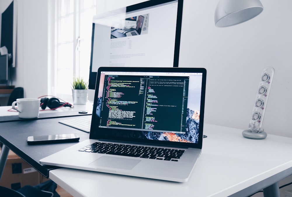 Laptop hiển thị trình soạn thảo code tại bàn làm việc hiện đại