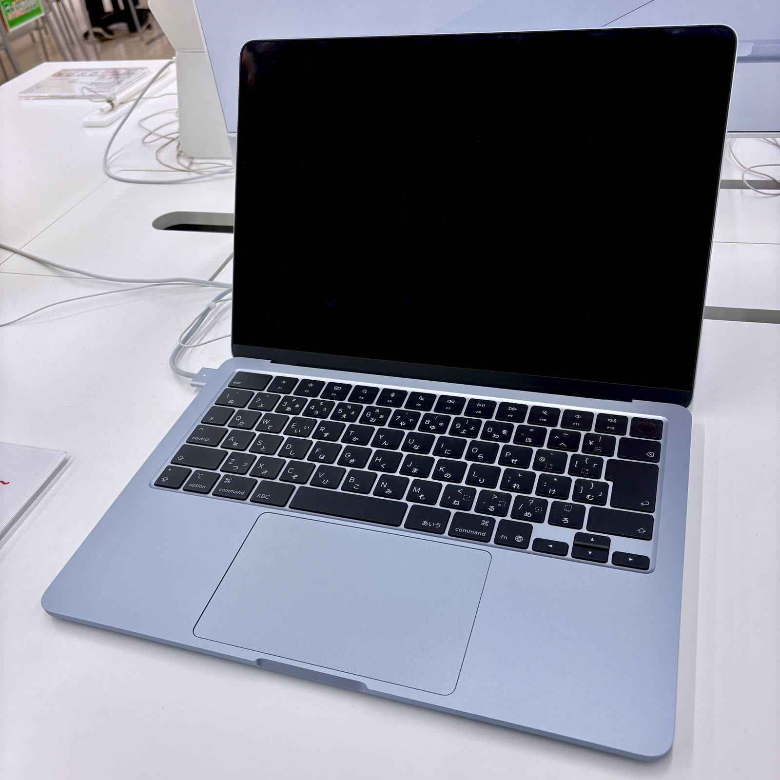 MacBook Air M5 màu xanh dương mở nắp đặt trên bàn, minh họa dòng laptop mỏng nhẹ của Apple