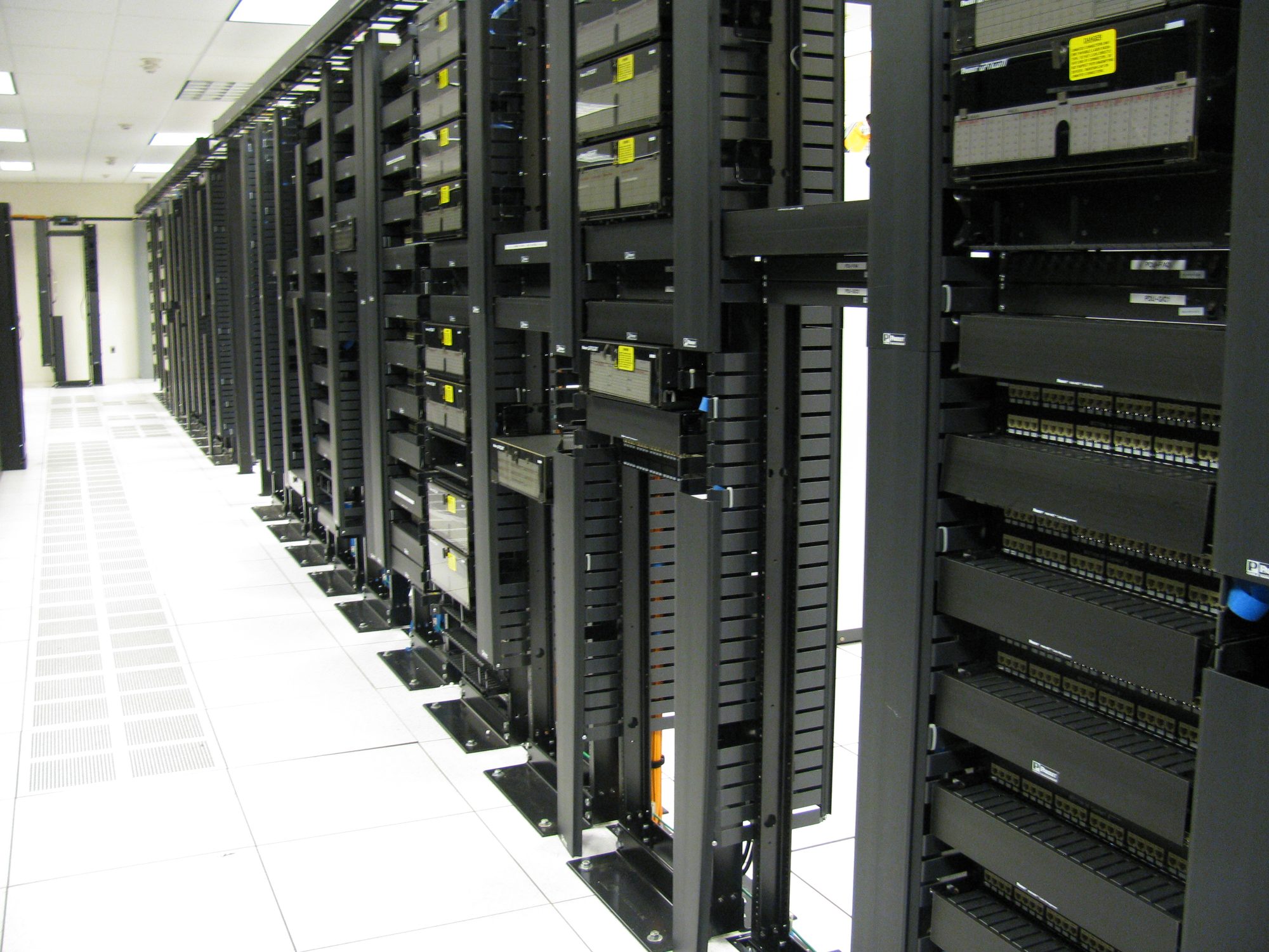 Hành lang trung tâm dữ liệu với hàng trăm server rack và hệ thống mạng