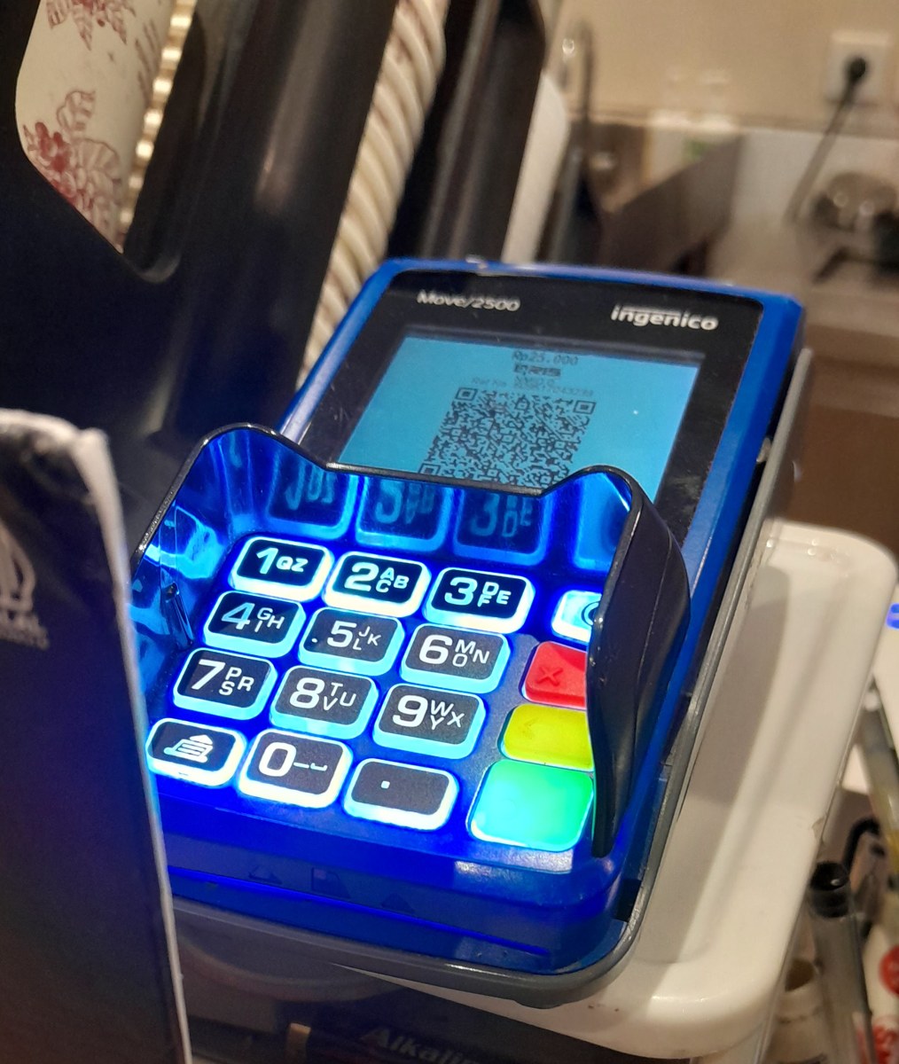 Máy POS Ingenico hiển thị mã QR thanh toán 25.000 Rupiah cho khách hàng quét bằng điện thoại