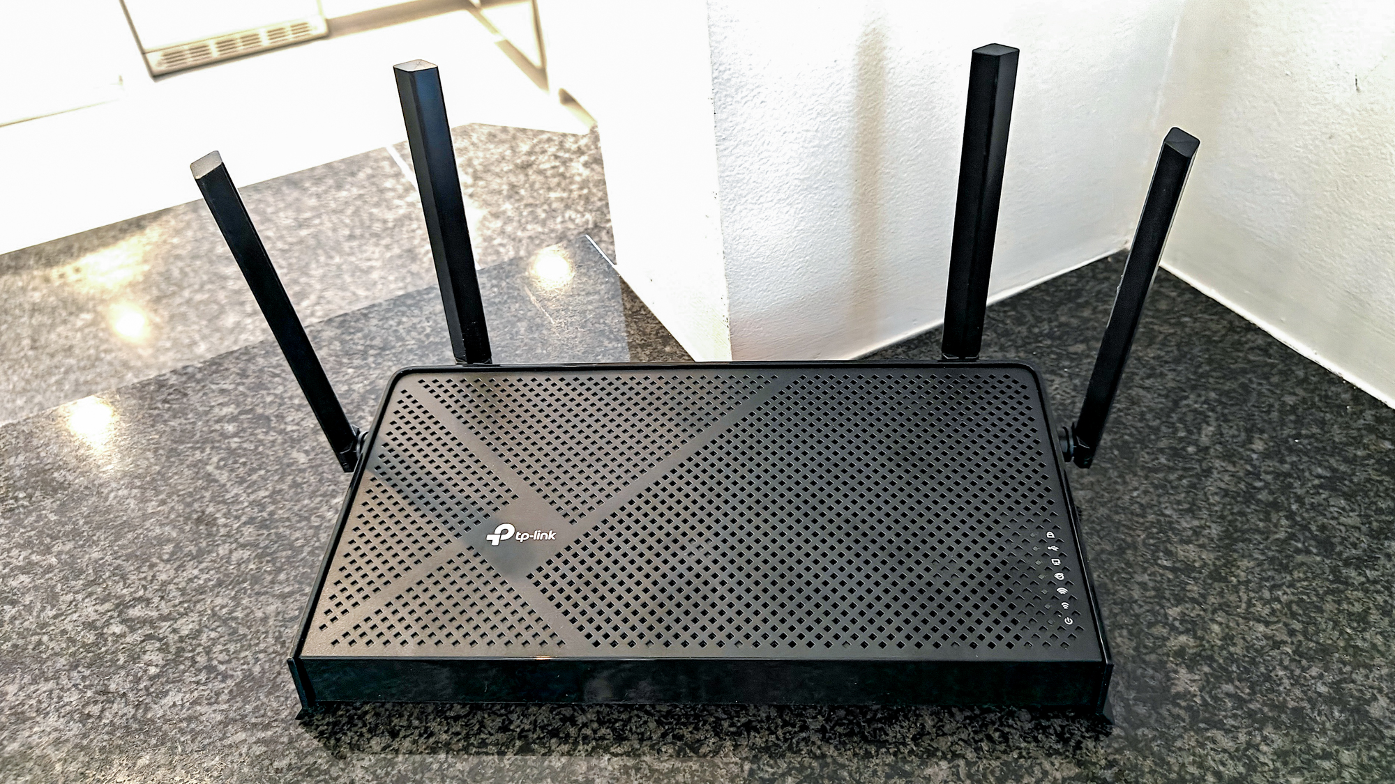 Router WiFi TP-Link Archer BE3600 màu đen với 4 ăng-ten ngoài trên quầy đá