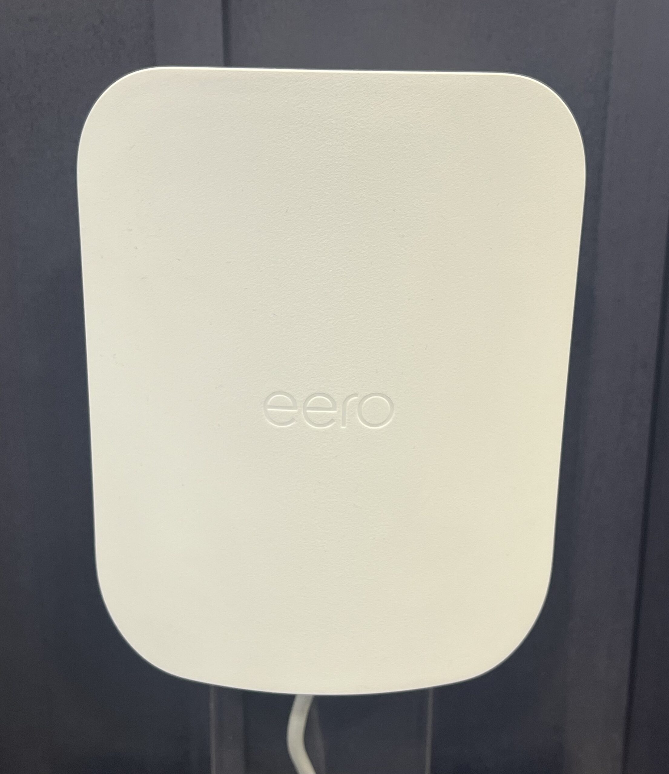 Thiết bị eero Outdoor 7 — router Wi-Fi 7 dạng mesh outdoor màu trắng, gắn trên tường ngoài trời