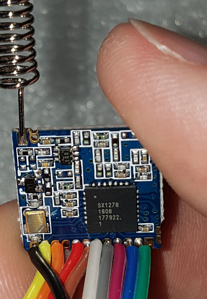 Module LoRa nhỏ gắn ăng-ten dây và bộ dây nối SPI, nằm trên mặt bàn
