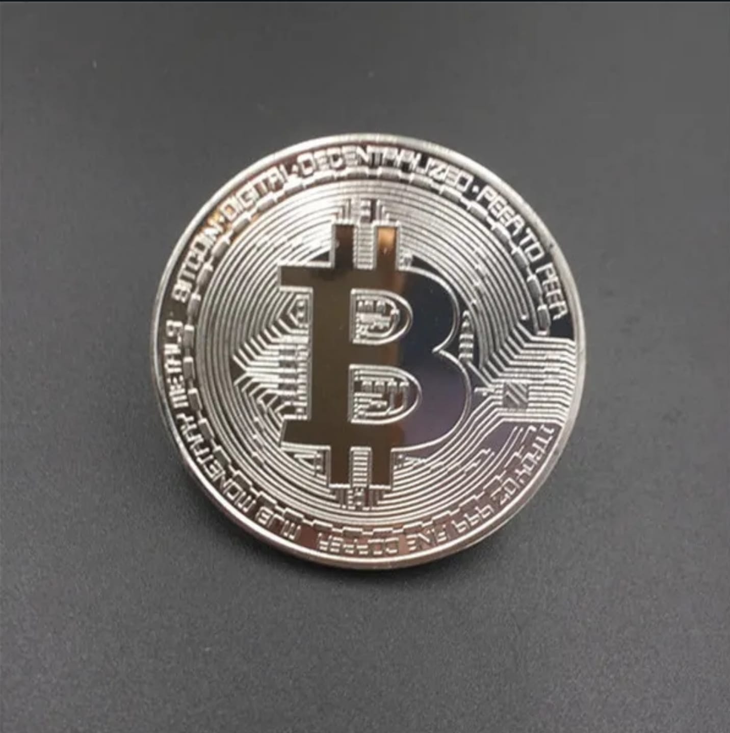 Ảnh thực tế một đồng Bitcoin vật lý làm bằng kim loại mạ vàng với ký hiệu Bitcoin khắc trên mặt
